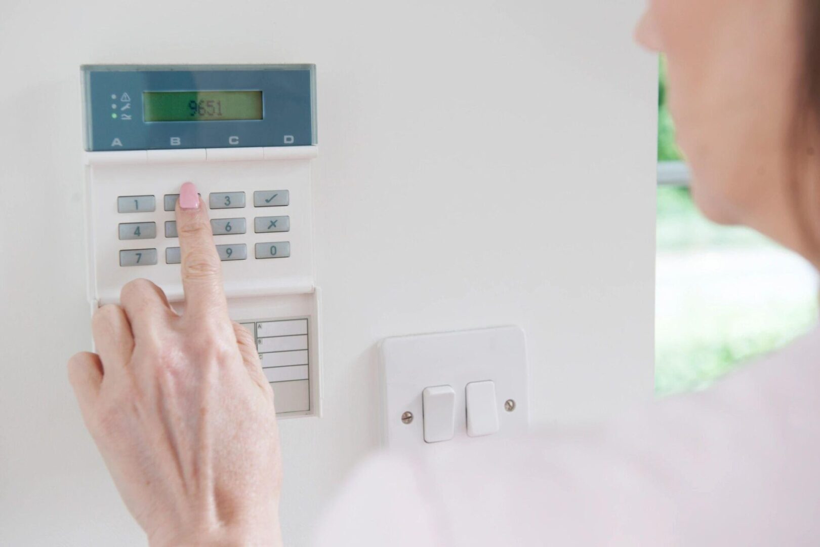 A person is touching the button on an alarm.