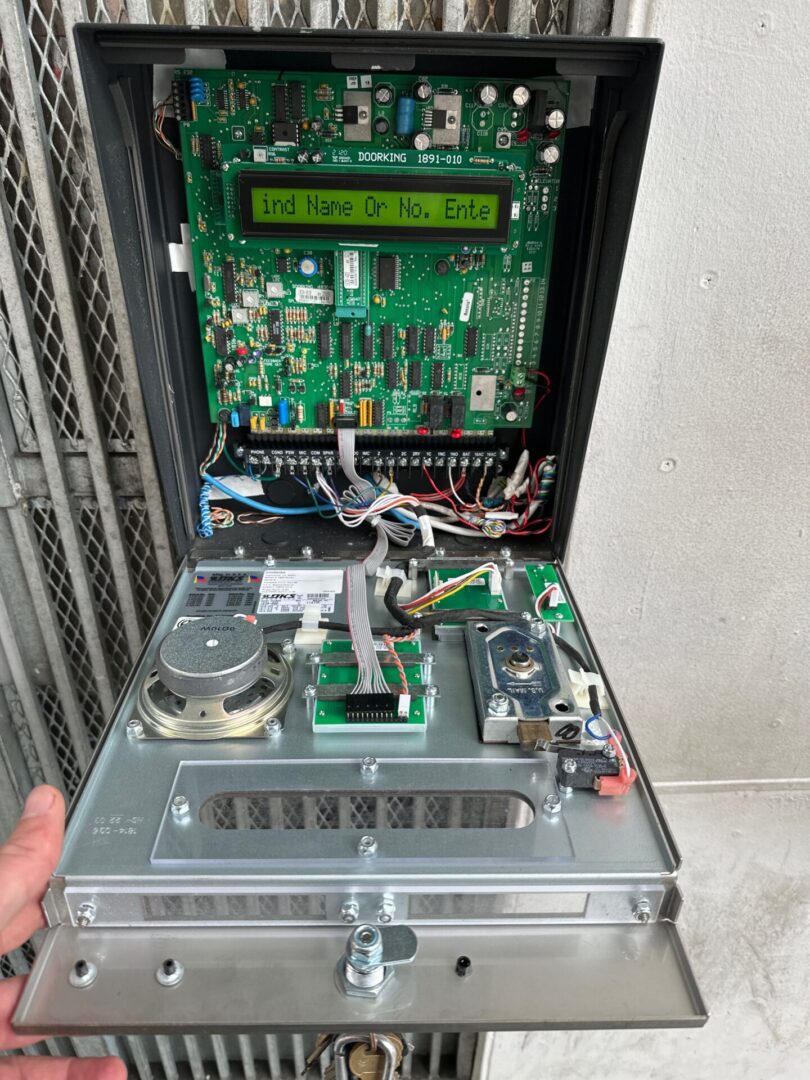 A person holding an open computer case with electronics inside.