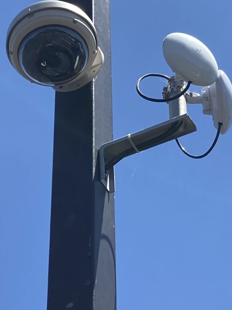 A close up of two cameras on top of a pole
