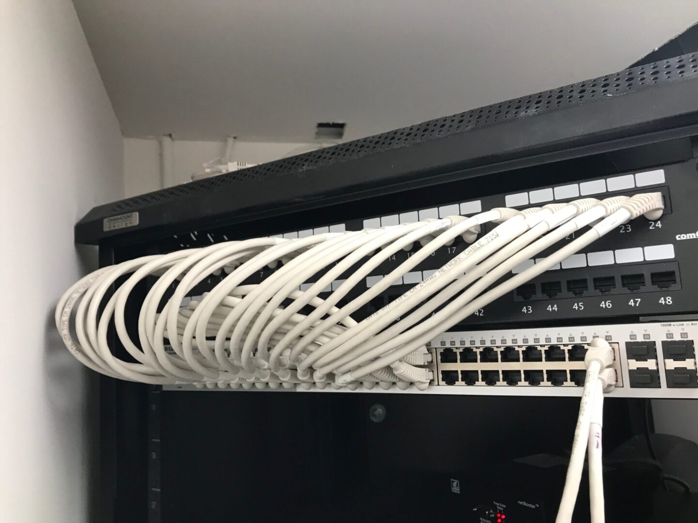 A bunch of wires hanging from the side of a rack.