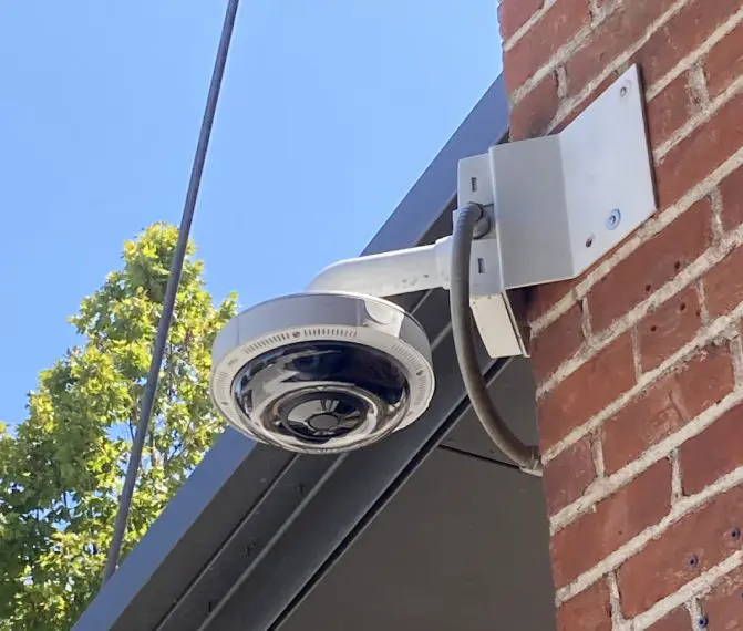 A security camera mounted to the side of a building.