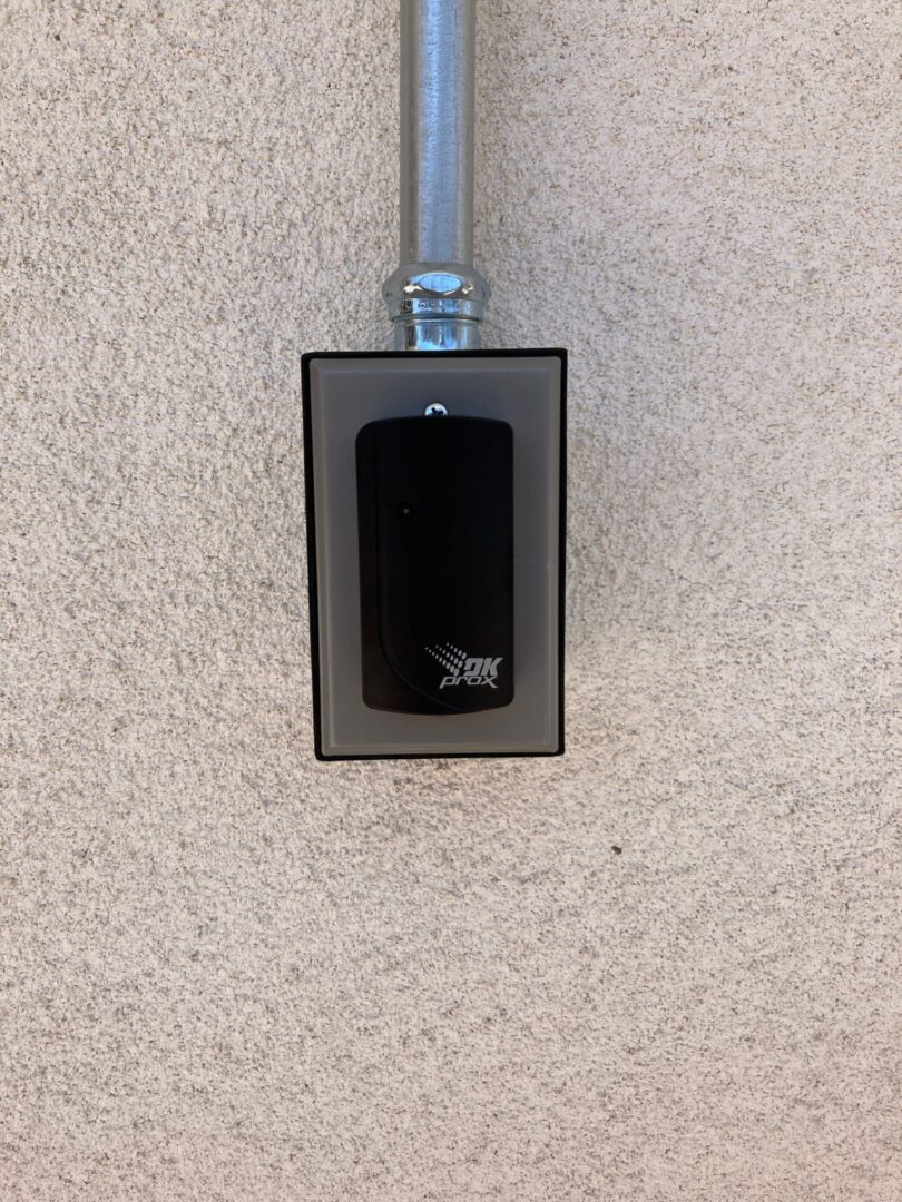 A black and silver key switch mounted on the wall.